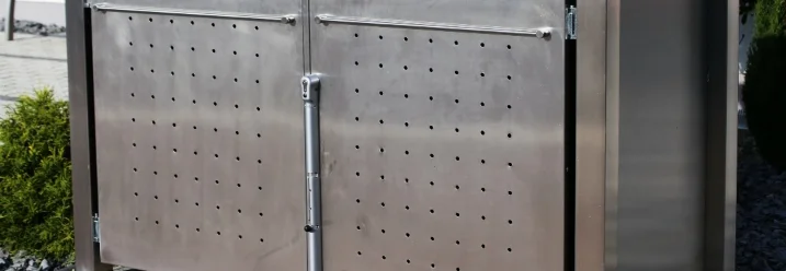 Metallische Mülltonnenbox mit bepflanztem Dach